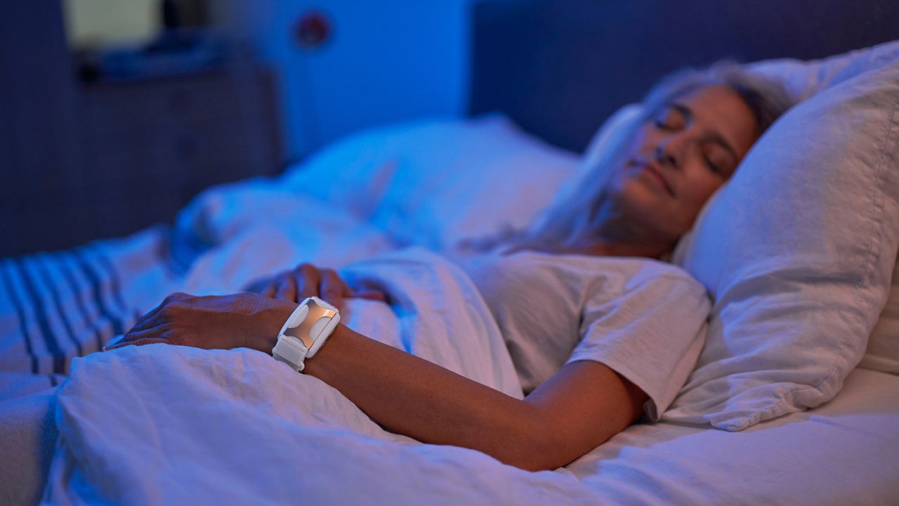 Person sleeping in bed with an Apollo wearable device on their wrist.