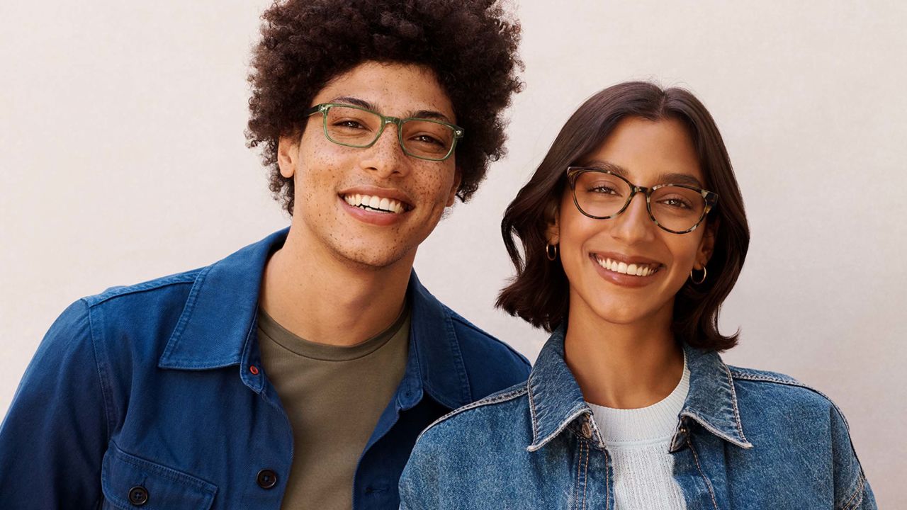 Two people smiling while wearing eyeglasses.