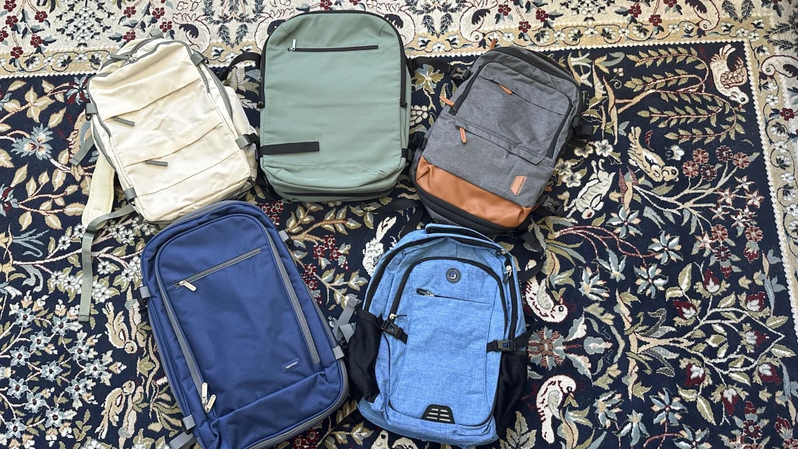 Five backpacks on a rug