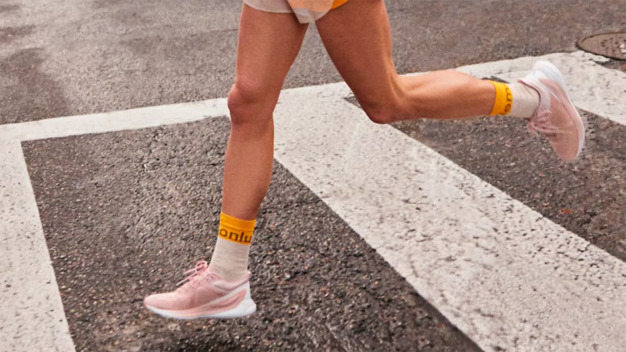 Person running in a crosswalk while wearing Lululemon sneakers.