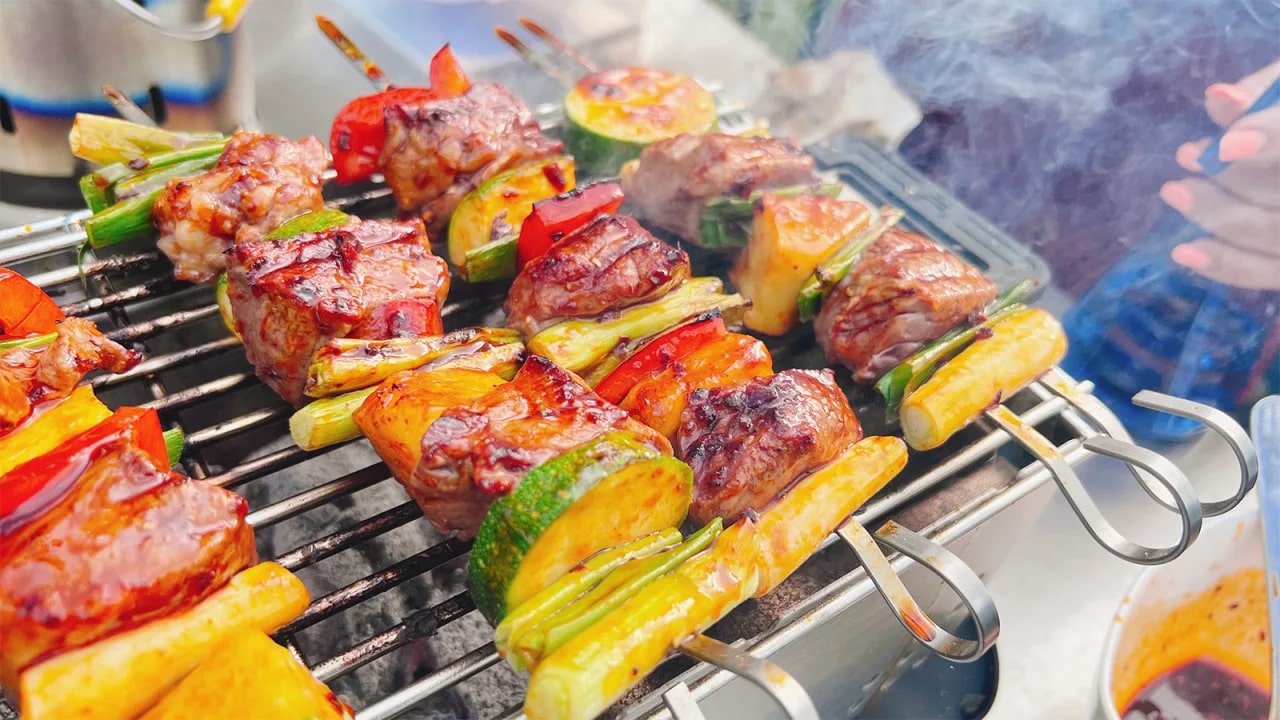 Four kebabs on a grill