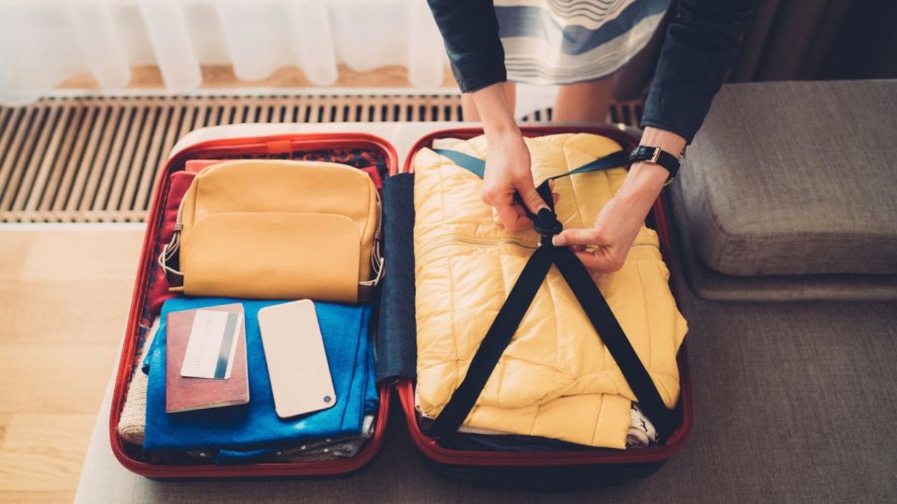 Person packing a suitcase.