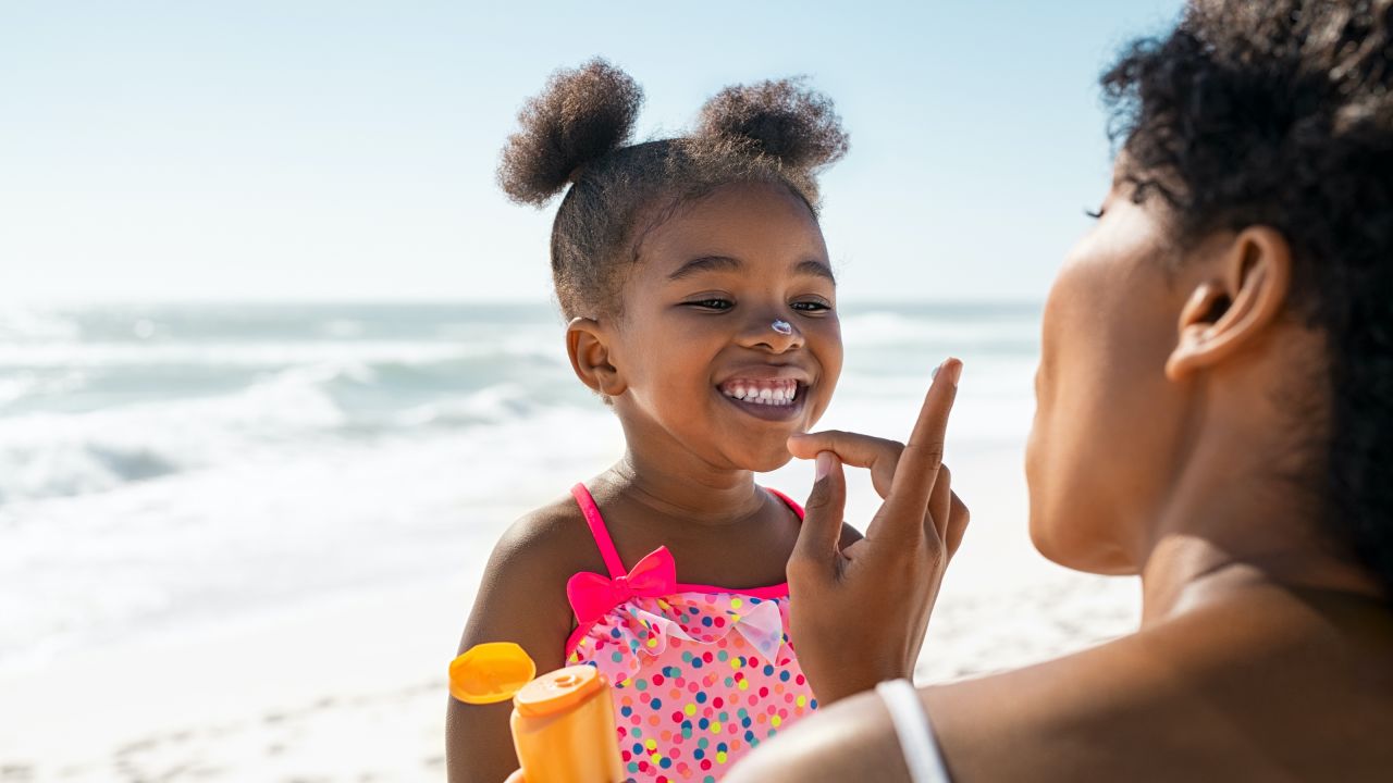 Parent putting sunscreen on a child