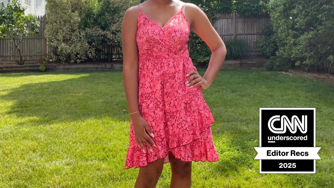 Woman standing on grass while wearing a pink ruffled dress